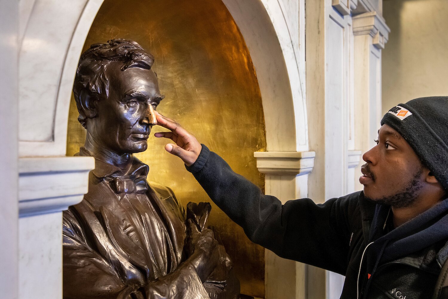 Student rubbing nose of Lincoln bust